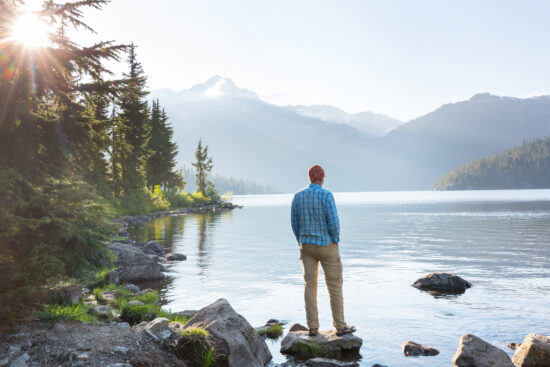 Hiker relaxing at serene mountain lake